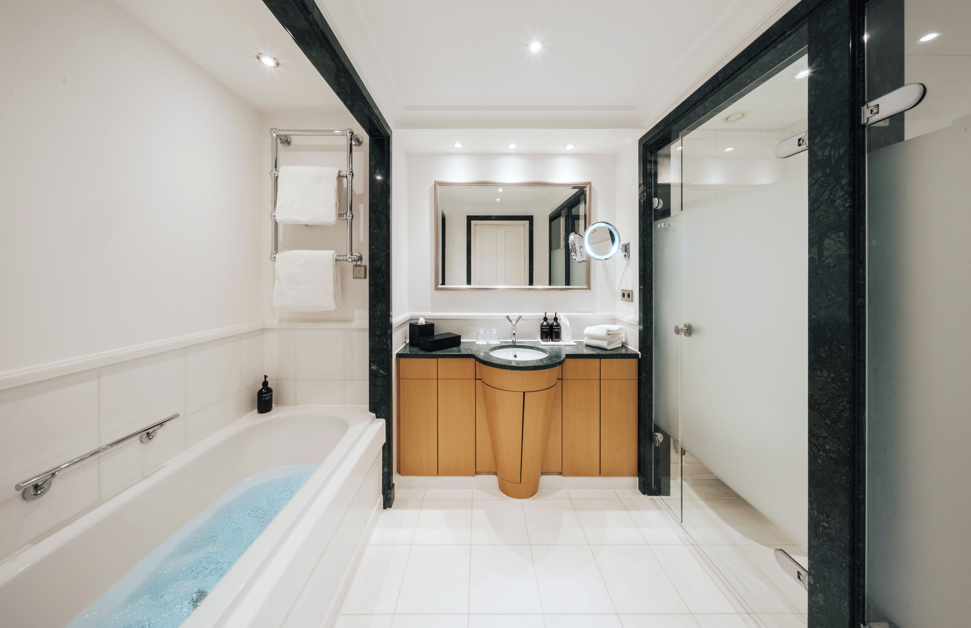 Un baño moderno con bañera, lavamanos y espejo.