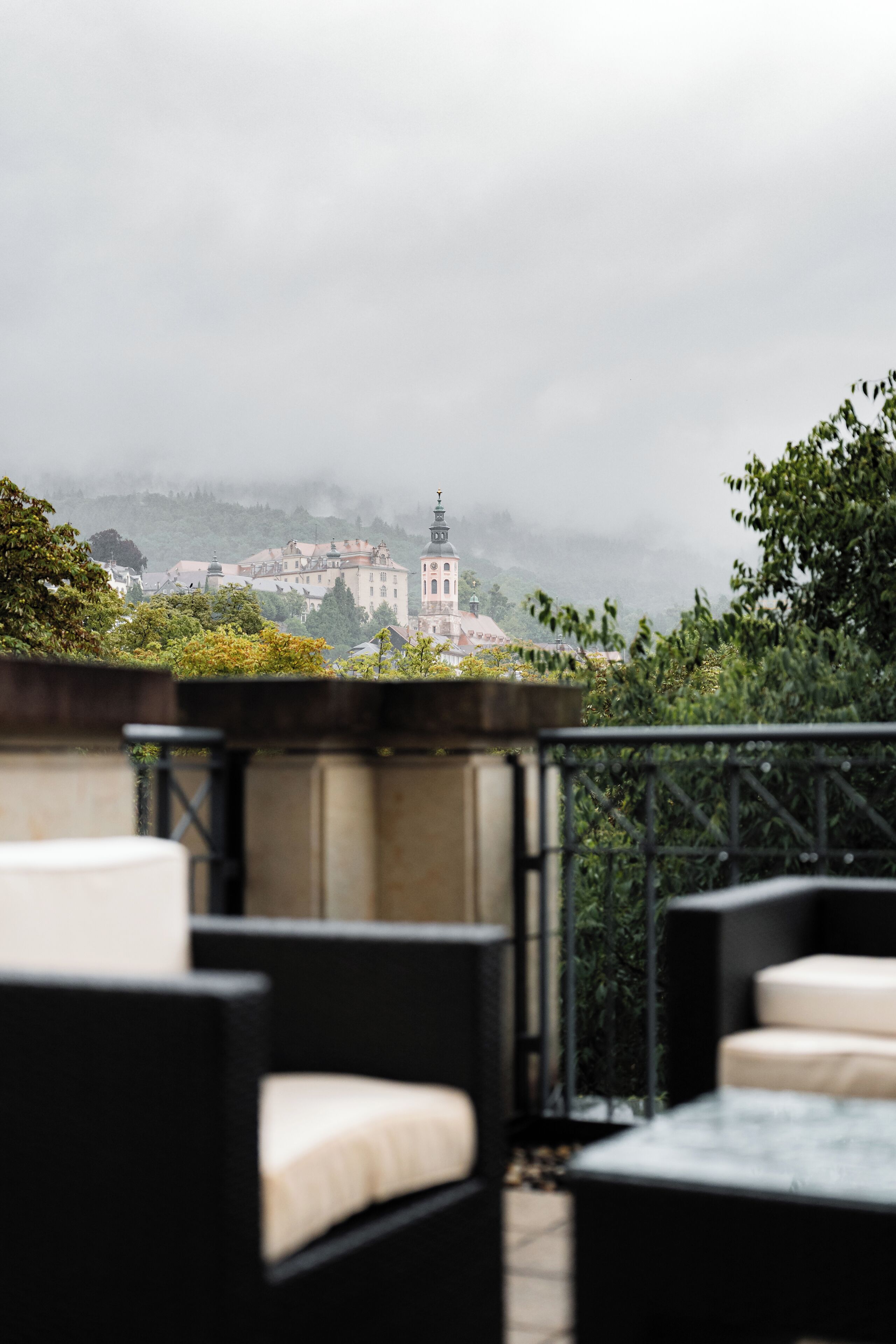 Una terraza con mobiliario exterior y vistas a un edificio histórico a lo lejos.