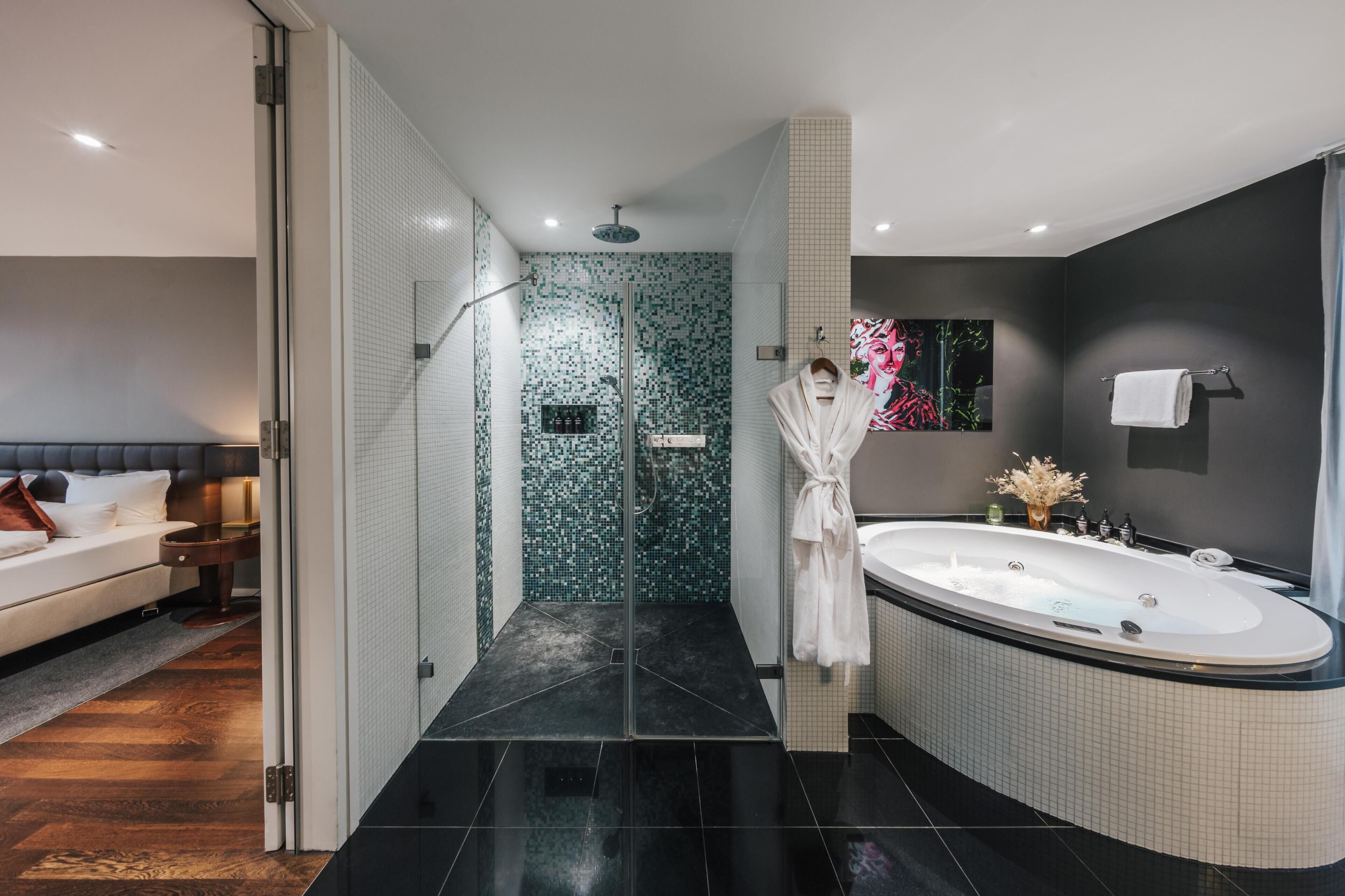 A modern bathroom with a glass shower enclosure, a large bathtub, and a separate shower area.