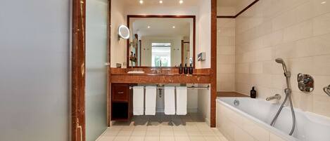 Un baño moderno con una bañera grande, un tocador con espejo y un perchero para toallas.