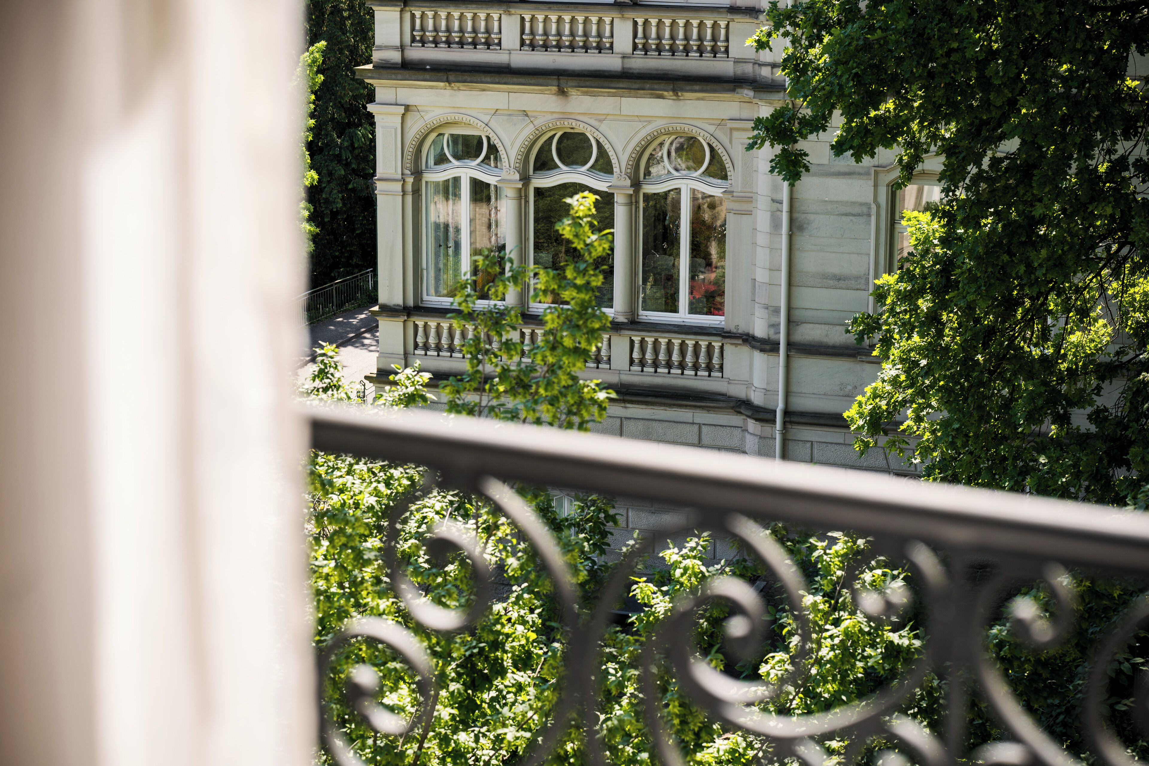 A building with three arched windows and a balcony with balustrades.
