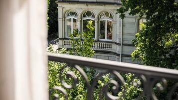 A building with three arched windows and a balcony with balustrades.
