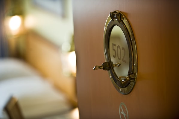 Primer plano de una placa con el número de habitación, 502, en una puerta de madera.
