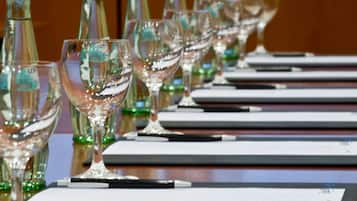 A row of wine glasses and bottles on a table with lined notepads.