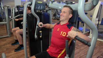 Un gimnasio con equipo de ejercicio, incluyendo una máquina de press de banca.