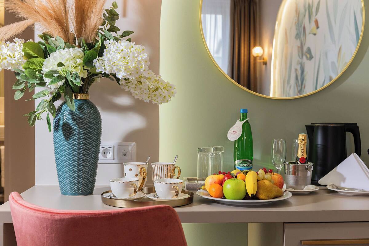 Ein Frühstückstisch mit Blumen in einer Vase, Obstteller und Kaffeekanne.