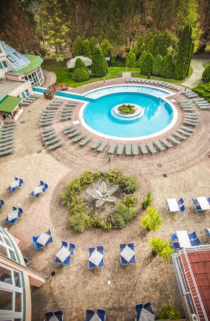A pool area with lounge chairs and a central garden. - Lotus Therme Hotel & Spa (Hévíz)
