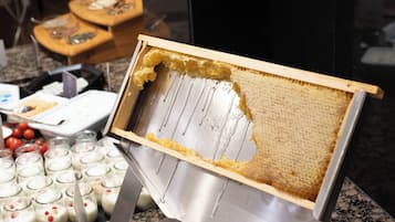 Montaje de bufé con diversos alimentos y una exhibición de panales.