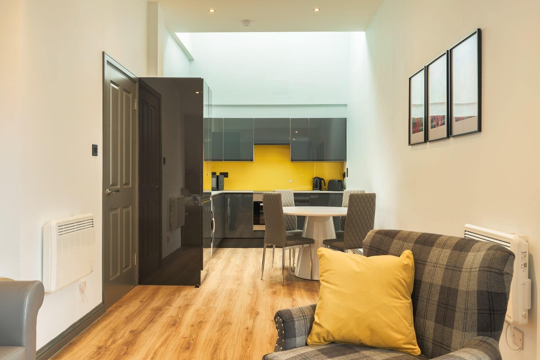 A modern apartment with a dining area, kitchen, and living room.