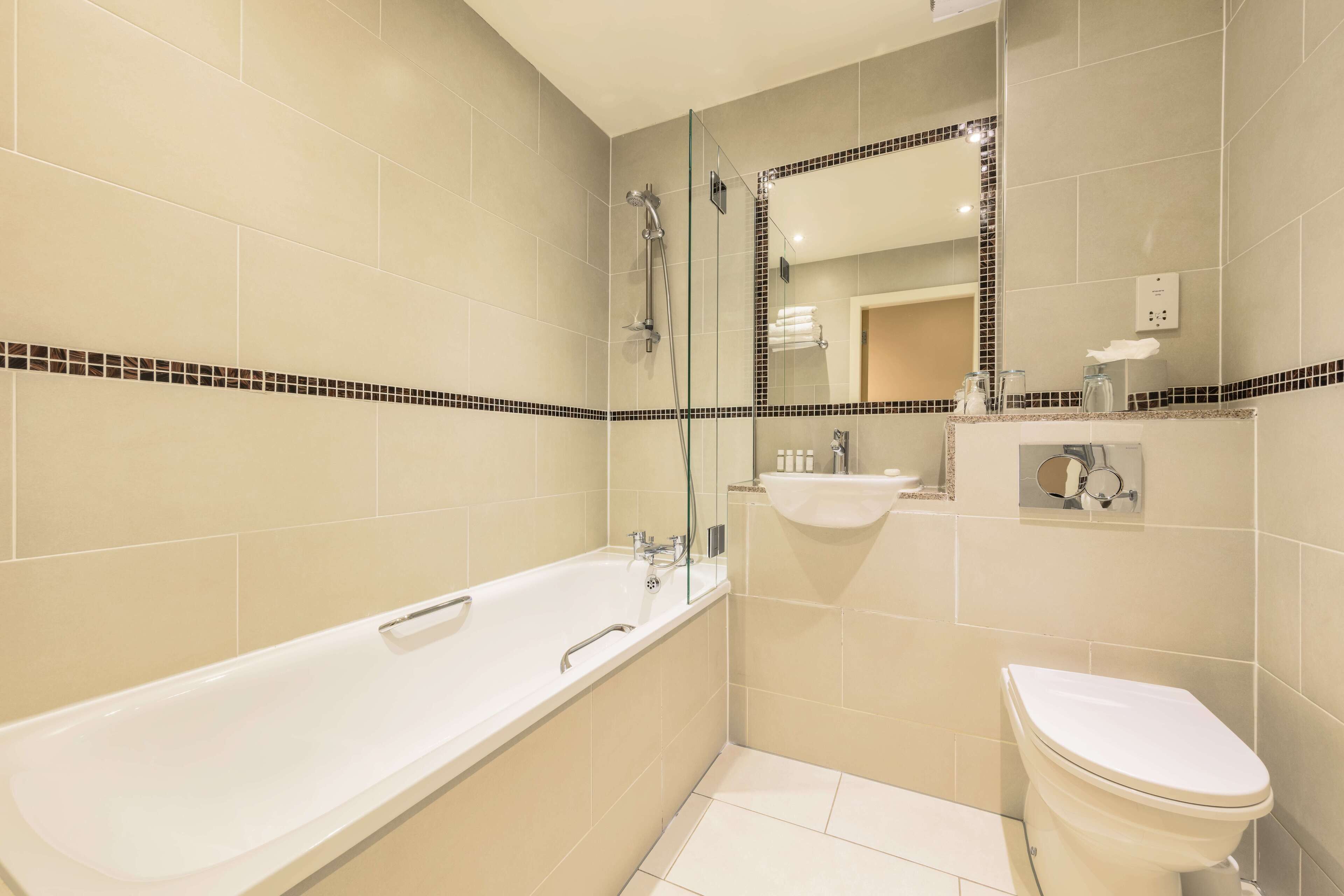 A modern bathroom with a bathtub, sink, and toilet.