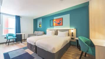 Una habitación de hotel moderna con una cama grande, dos mesitas de noche, un escritorio y una silla.
