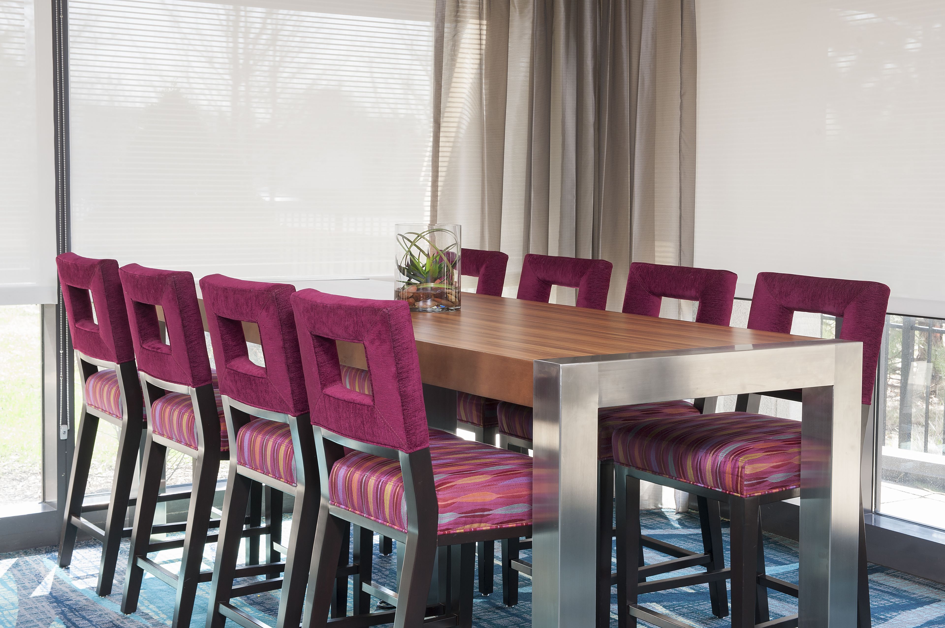 Comedor con mesa de madera y sillas tapizadas en morado.