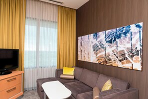 Suite, 1 cama de matrimonio grande con sofá cama | Zona de estar | Una televisión de plasma