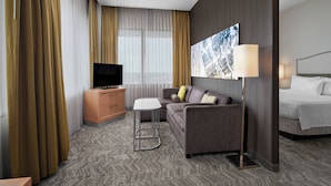 A hotel room with a sofa, a TV, a desk, a lamp, and a bed. - SpringHill Suites Chicago O'Hare by Marriott (Chicago)