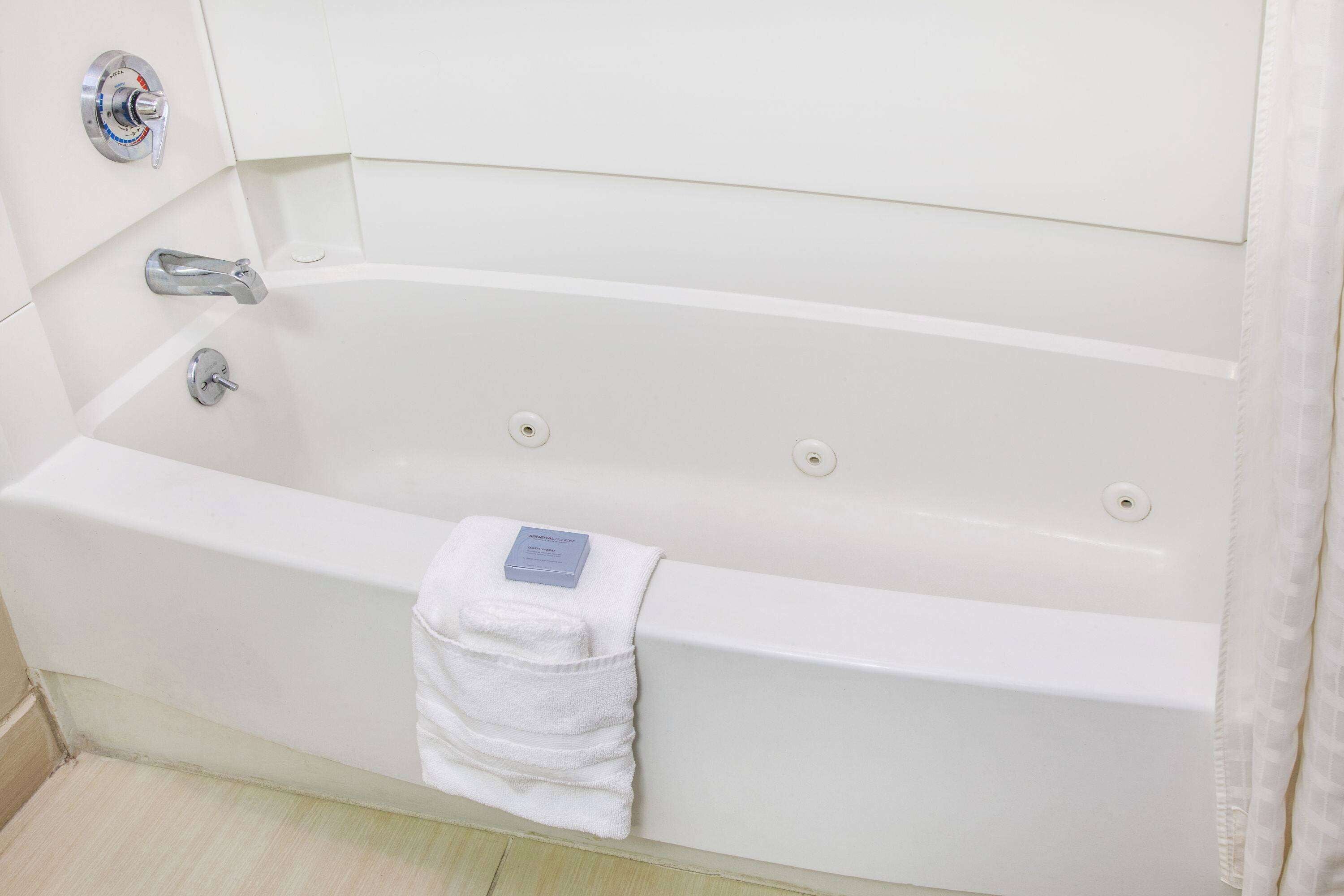 A white bathtub with a single faucet and a towel.
