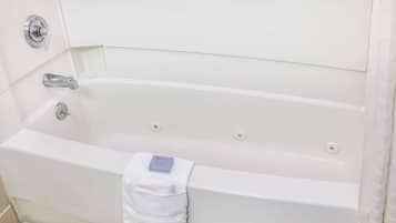 A white bathtub with a single faucet and a towel.