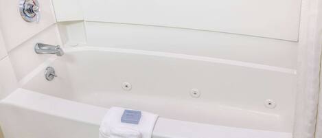 A white bathtub with a single faucet and a towel.