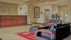 A lobby with a reception desk, seating area, and artwork on the walls.