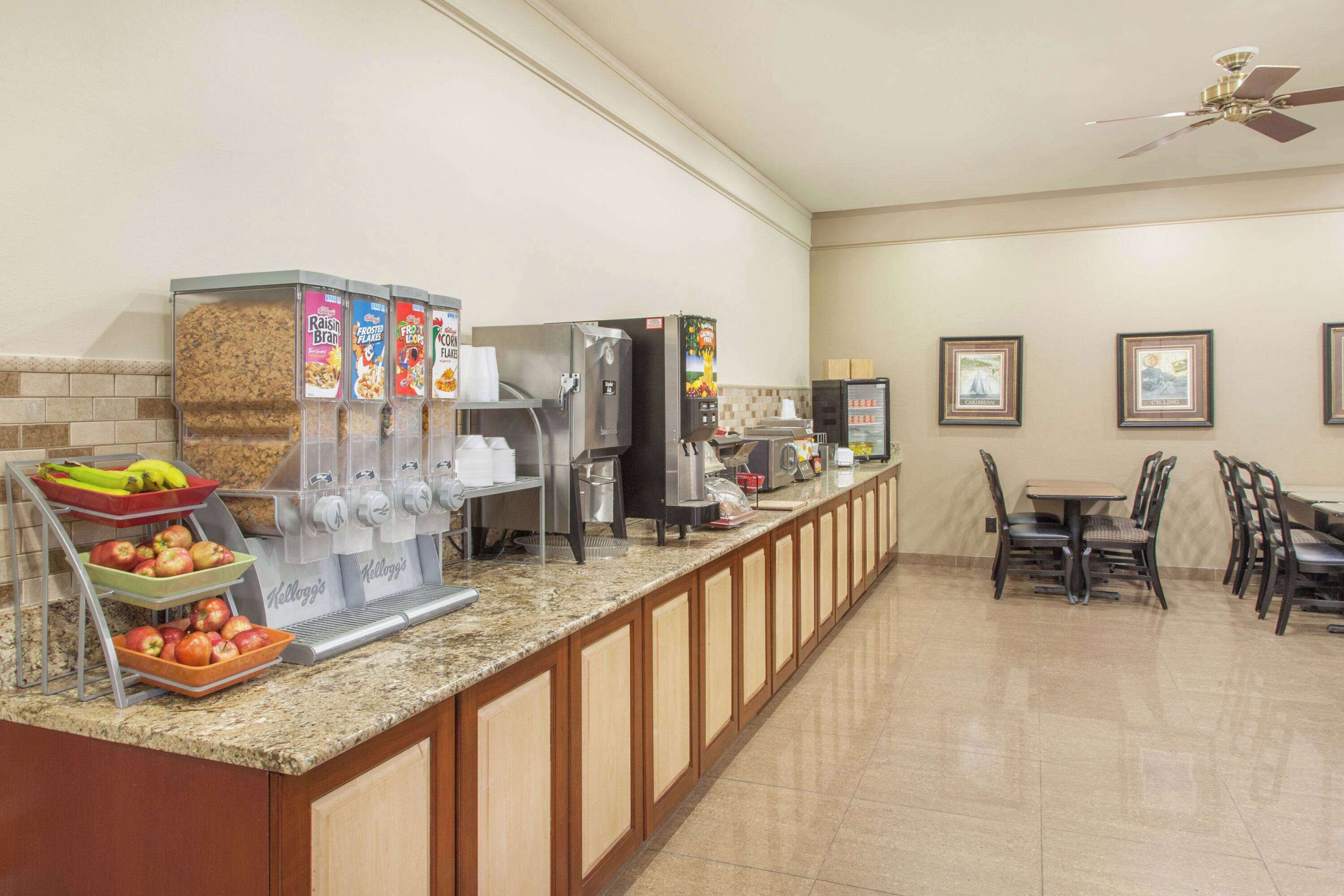 A breakfast bar with a fruit bowl, cereal dispensers, and a coffee machine.