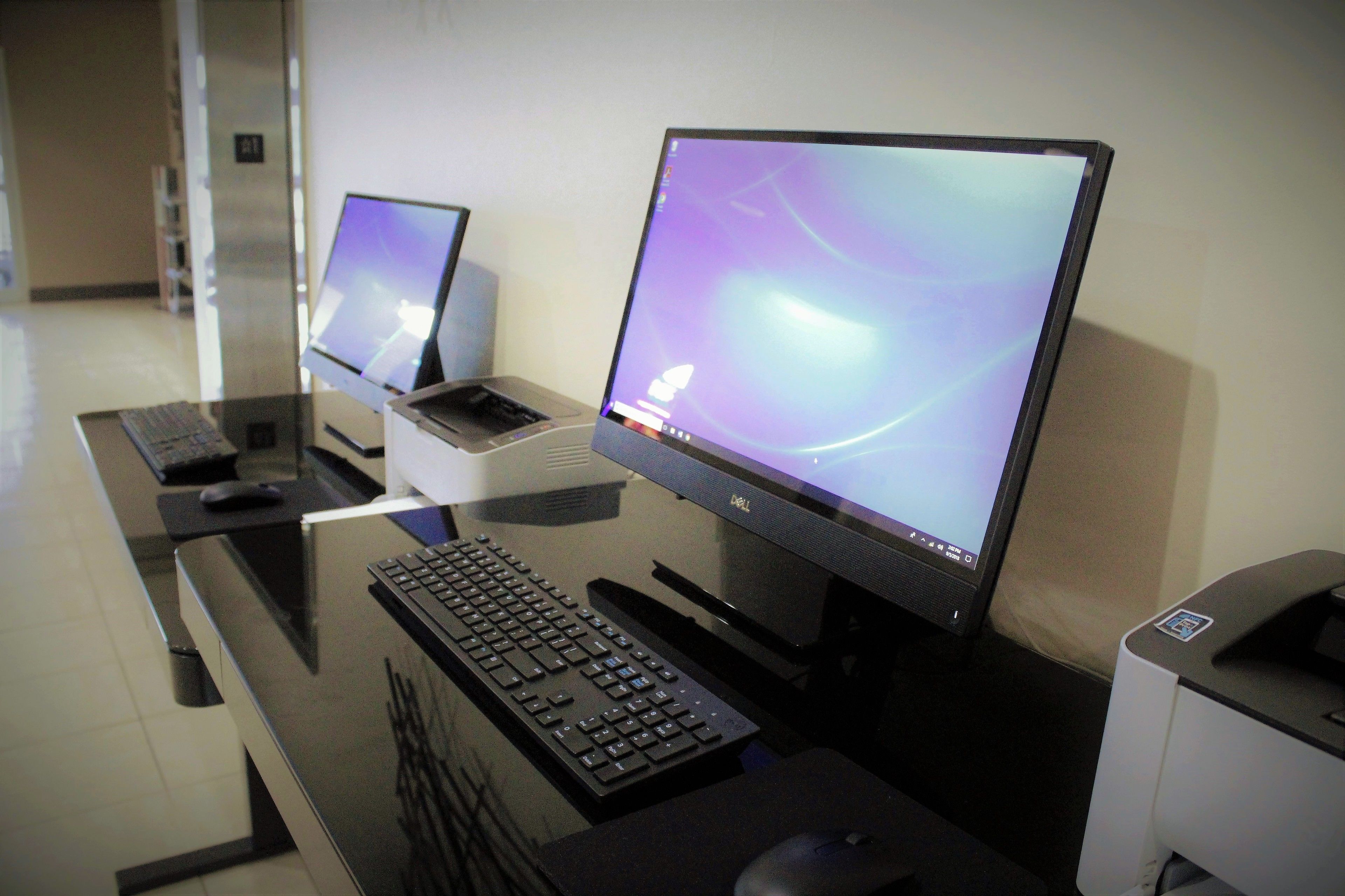 A modern office desk with two monitors, a keyboard, and a mouse.