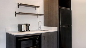 A compact kitchenette with a built-in microwave, a coffee maker, a toaster, and a sink. - Studio 6 Pensacola, FL - West I-10 (Pensacola)