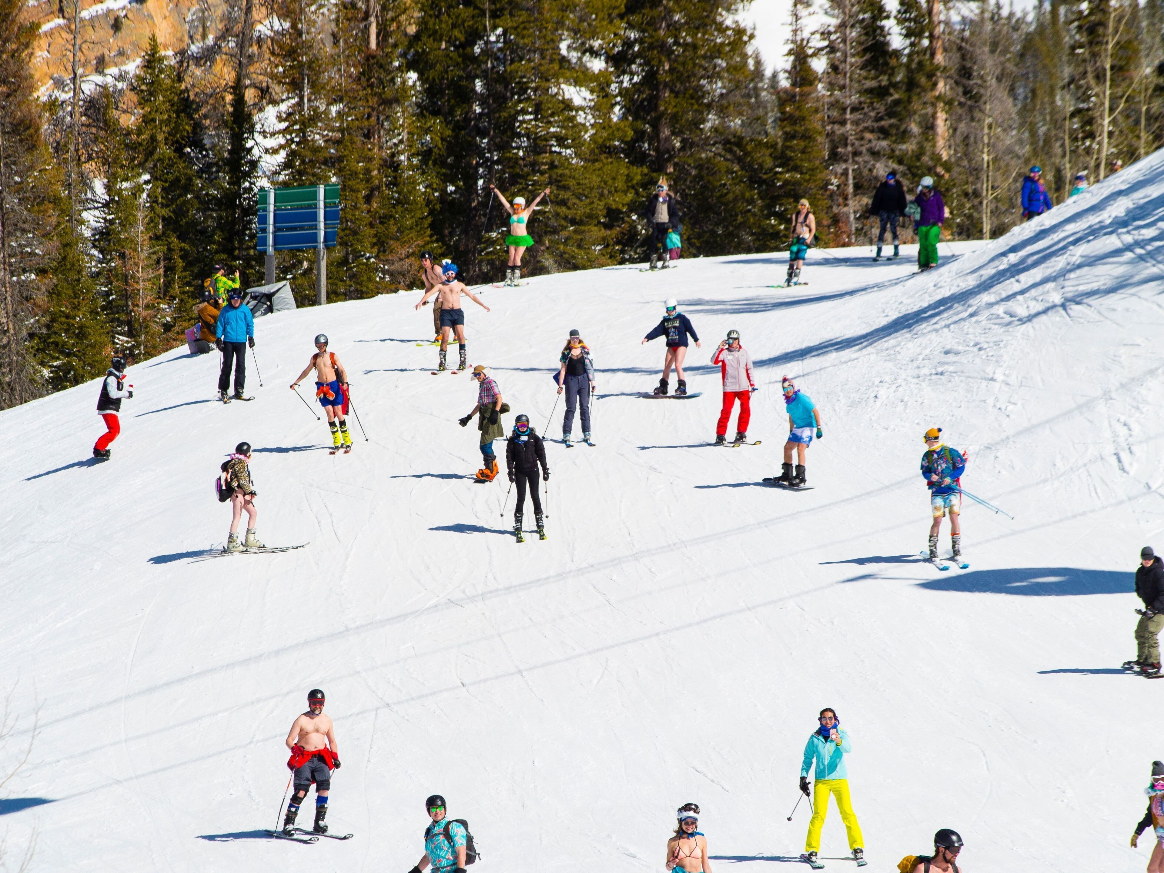 Een piste met skiërs en snowboarders.