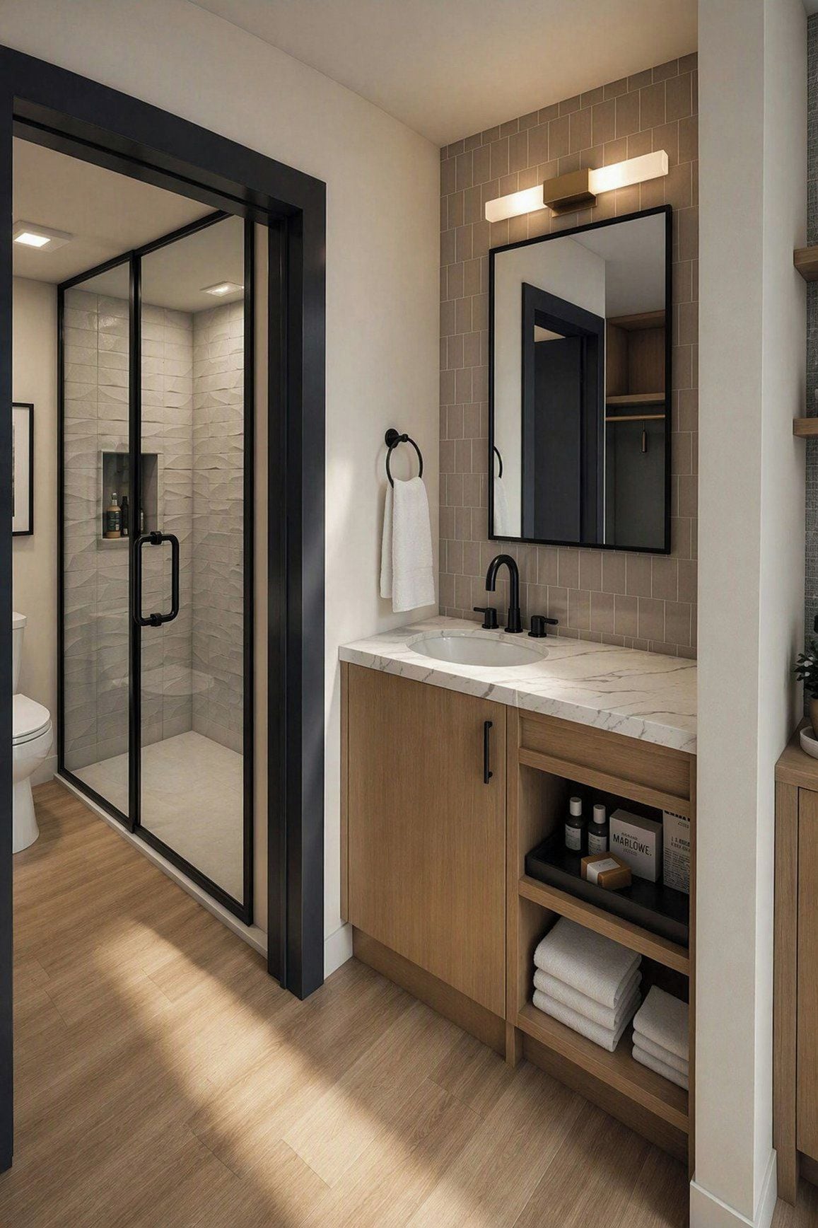 Un baño moderno con ducha envuelta en vidrio, tocador con espejo y lavamanos.