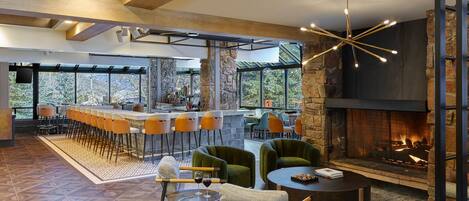 A spacious indoor area with a bar, seating, and a fireplace.