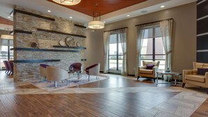 A spacious lobby with a stone wall, modern furniture, and large windows. - Drury Inn & Suites Kansas City Overland Park (Overland Park)