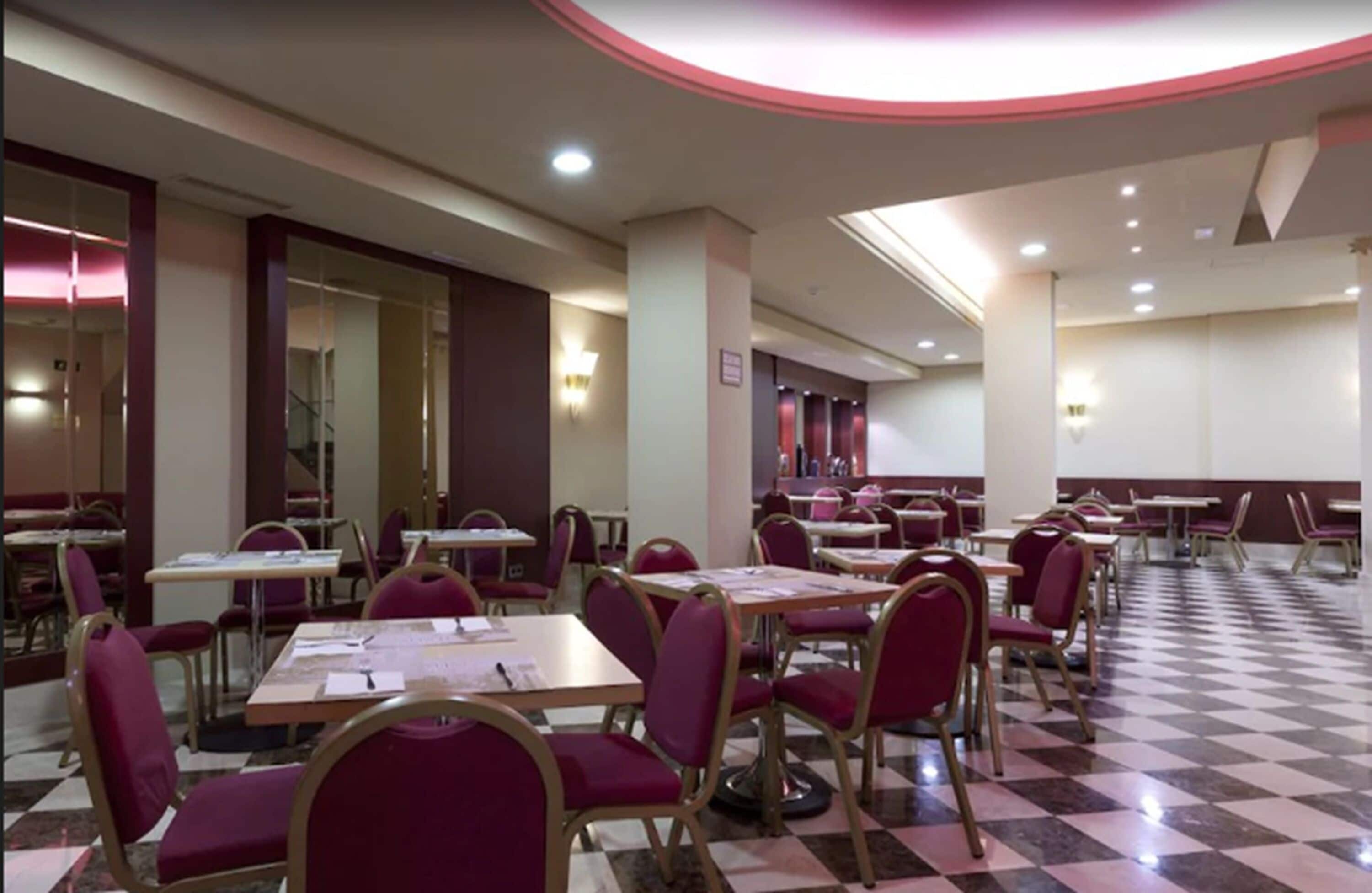 A dining area with checkered flooring, tables, and chairs.