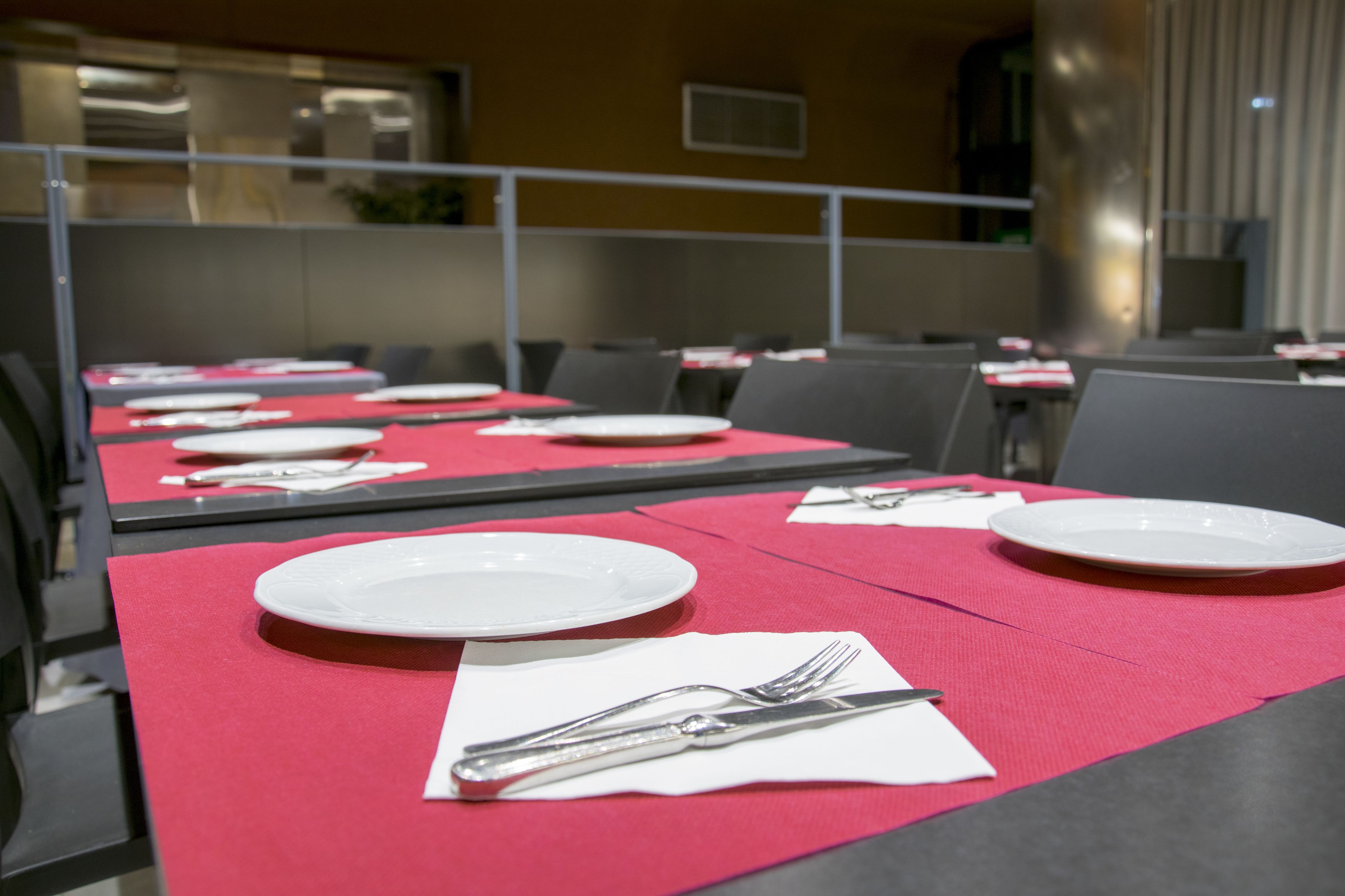 Una sala conferenze con tavoli apparecchiati per una riunione.