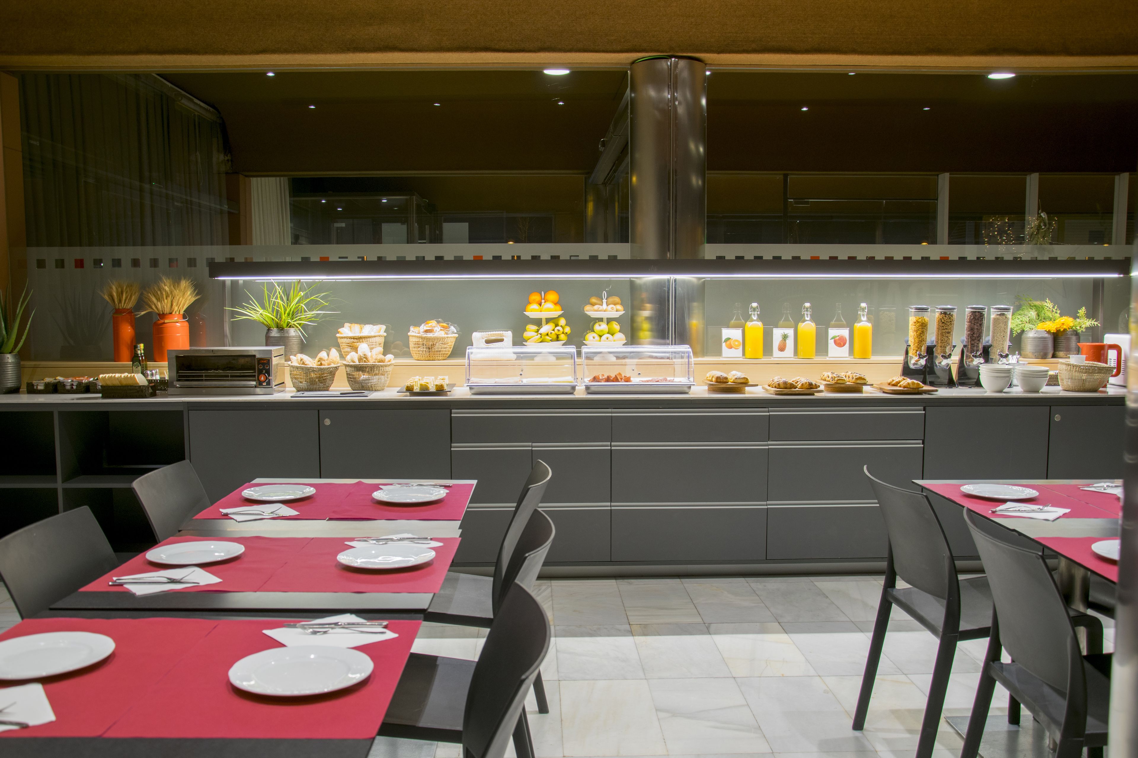 Un restaurante moderno con un sistema de buffet, que ofrece diversas estaciones de comida y bebida.