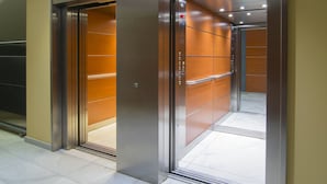 An elevator with metallic doors and a control panel. - Hotel America (Igualada)