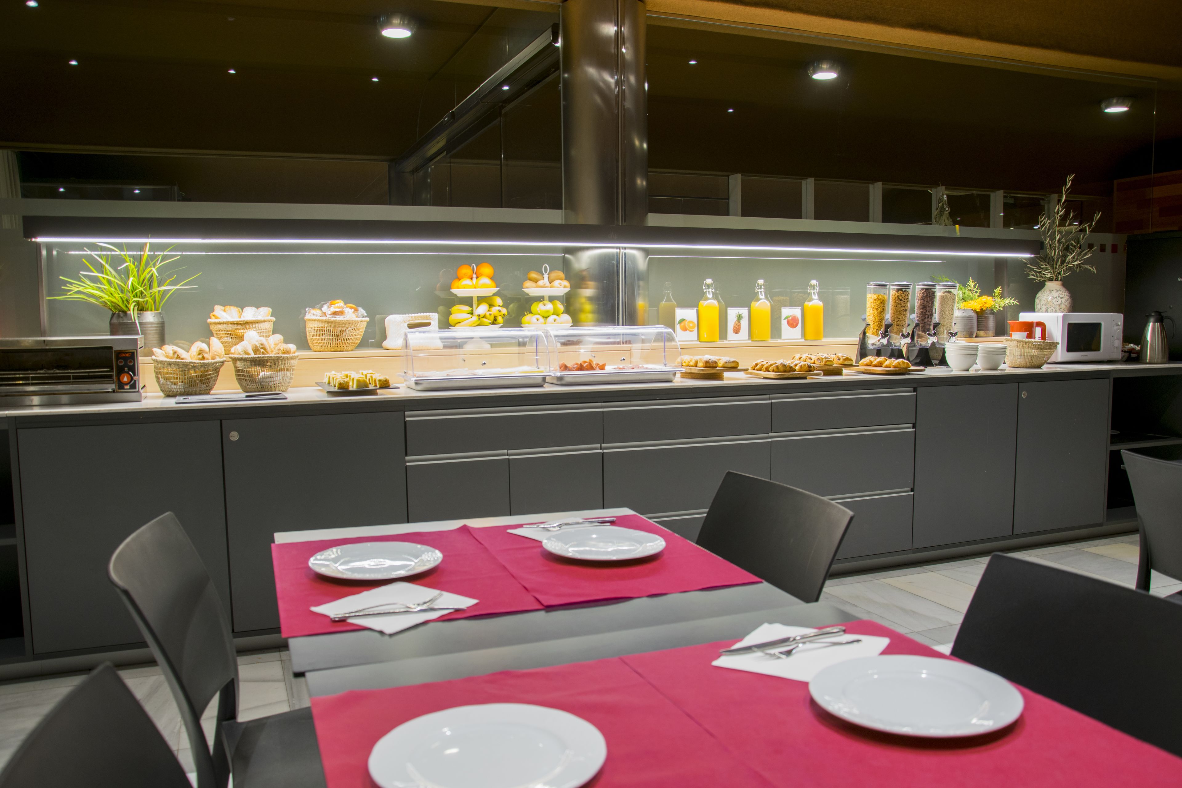 A modern breakfast bar with a variety of food items and beverages, a clean and organized layout, and a contemporary design.