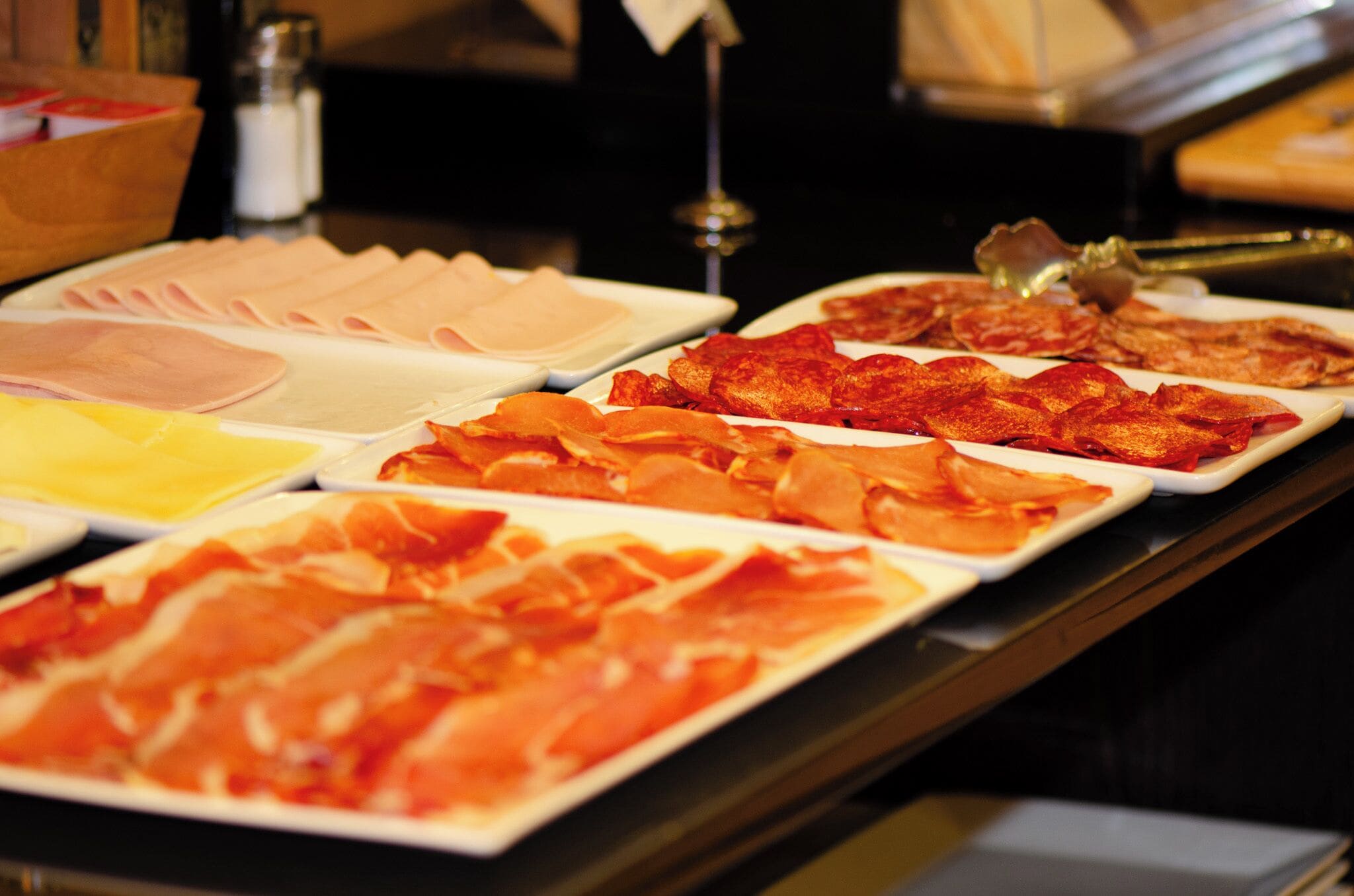 Un bufé con diversos tipos de carnes y quesos.