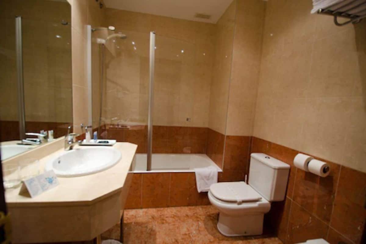 Kombinasi shower/bathtub, pengering rambut, kloset, dan handuk