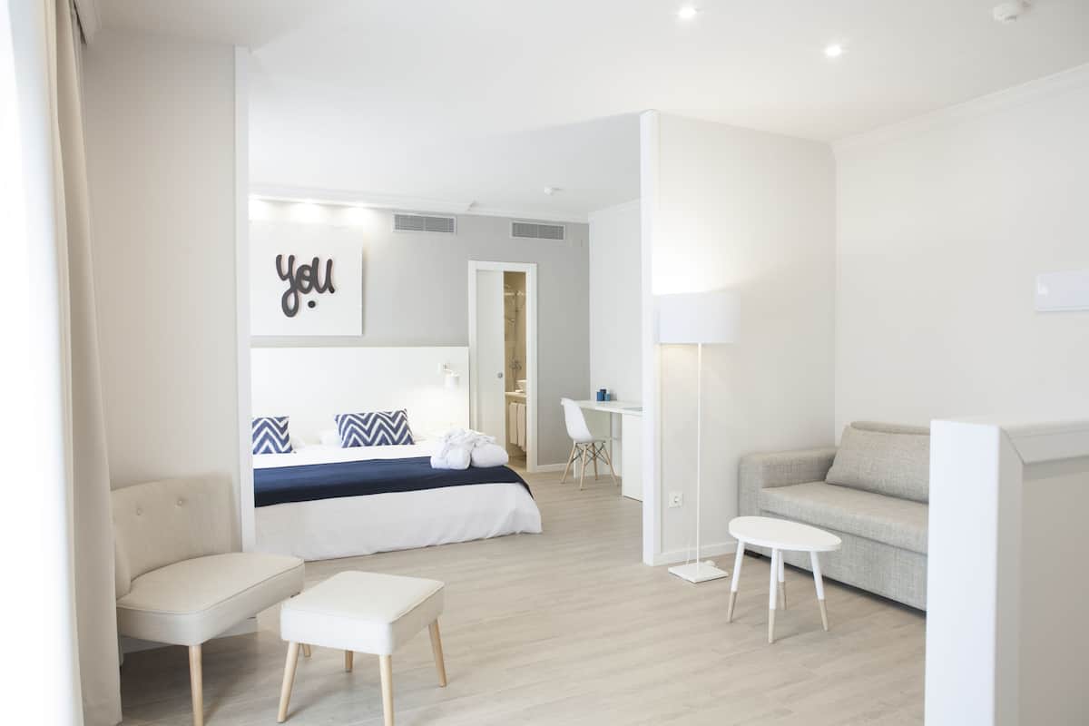 Een moderne hotelkamer met een bed, een bureau, een bank en een kleine tafel.