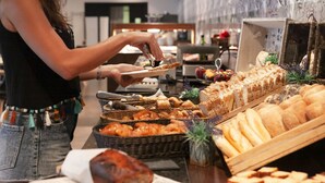 A buffet with various breads and pastries.