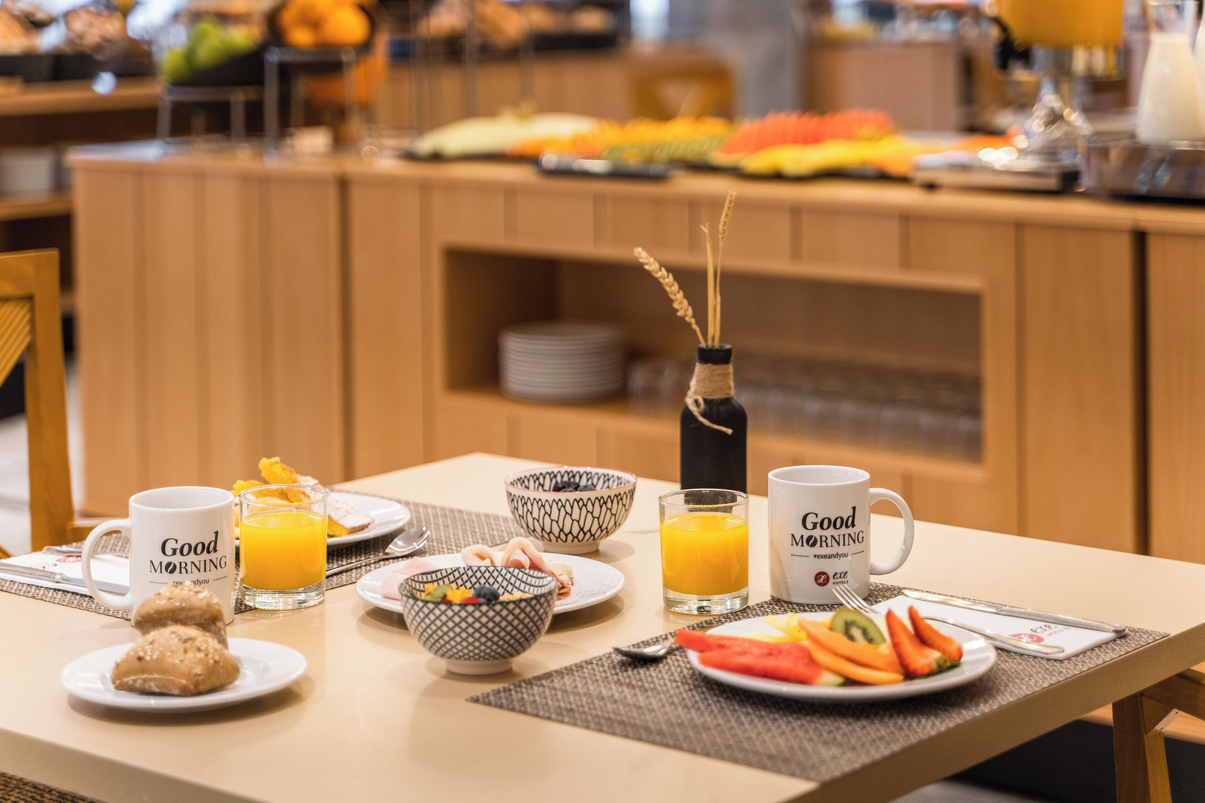 A breakfast buffet with various fruits, vegetables, and pastries.