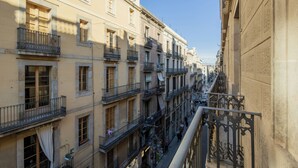 A multi-story building with balconies and a narrow street. - Gran Hotel Barcino (Barcelona)
