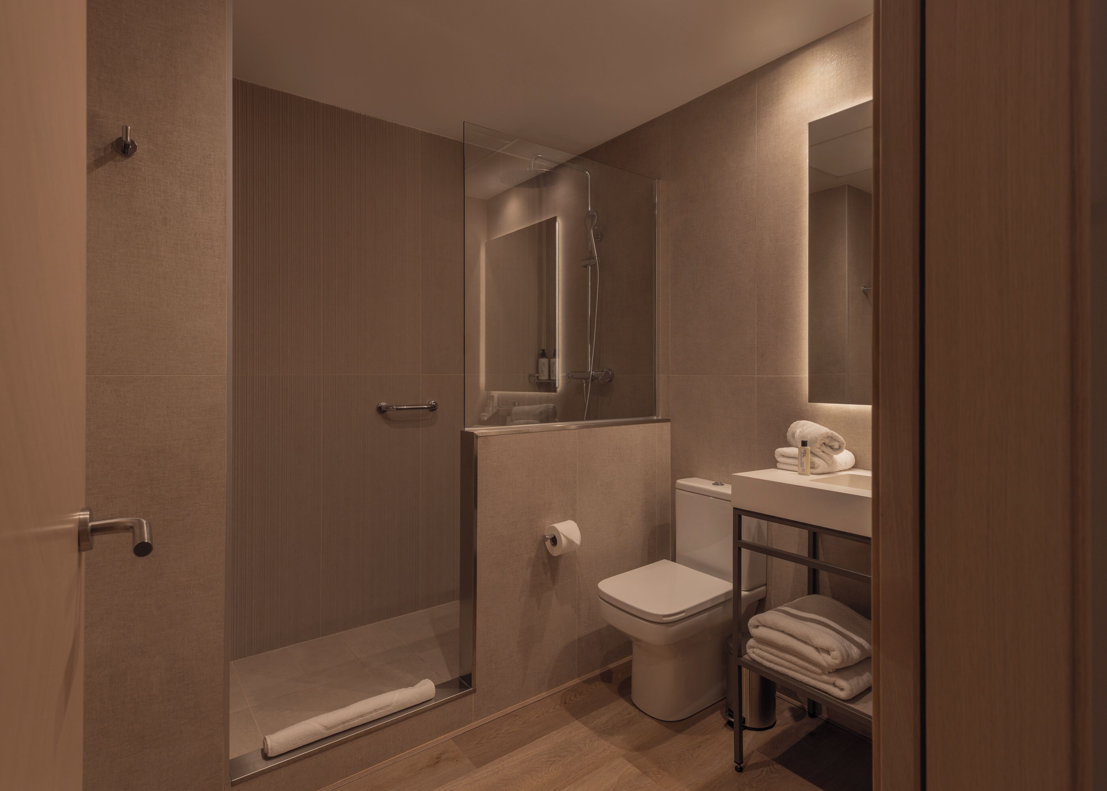 A modern bathroom with a shower, toilet, and sink.