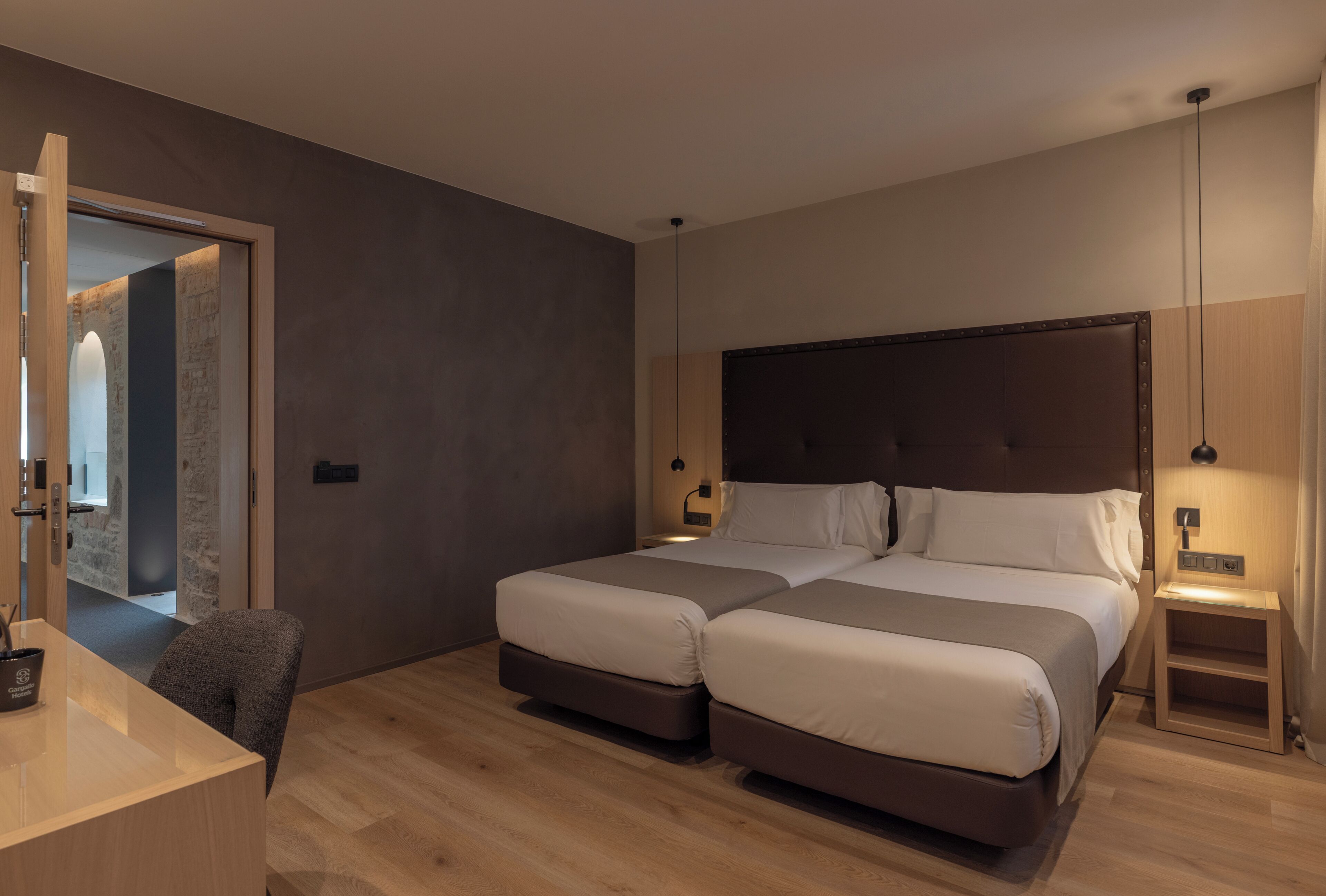 Una habitación de hotel moderna con dos camas, un escritorio y una silla.