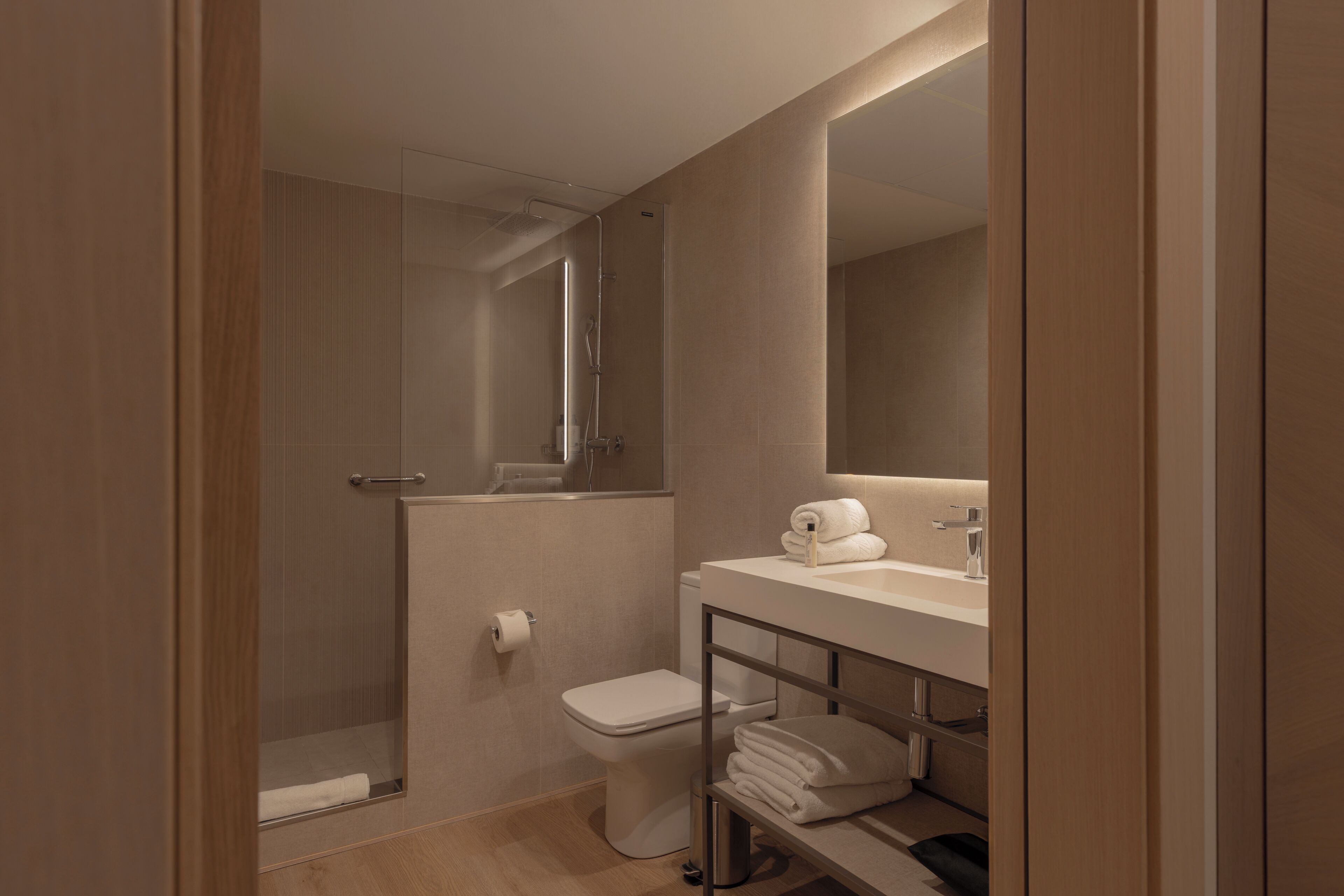 A modern bathroom with a shower, toilet, and sink.
