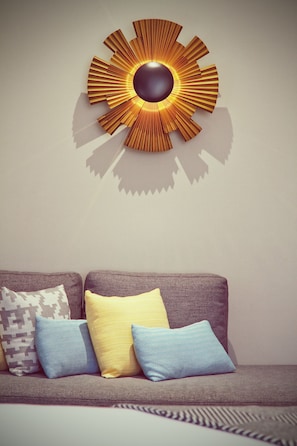 Relax in this stylish living room with a comfortable sofa and a striking wall art piece.