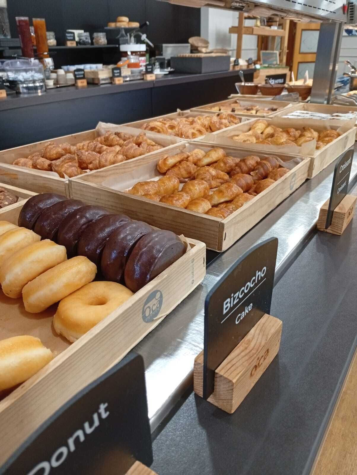 Eine Bäckertheke mit verschiedenen Backwaren, darunter Donuts und Gebäck.