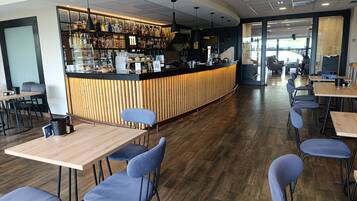 A modern café with a wooden counter, seating area, and a visible menu board.