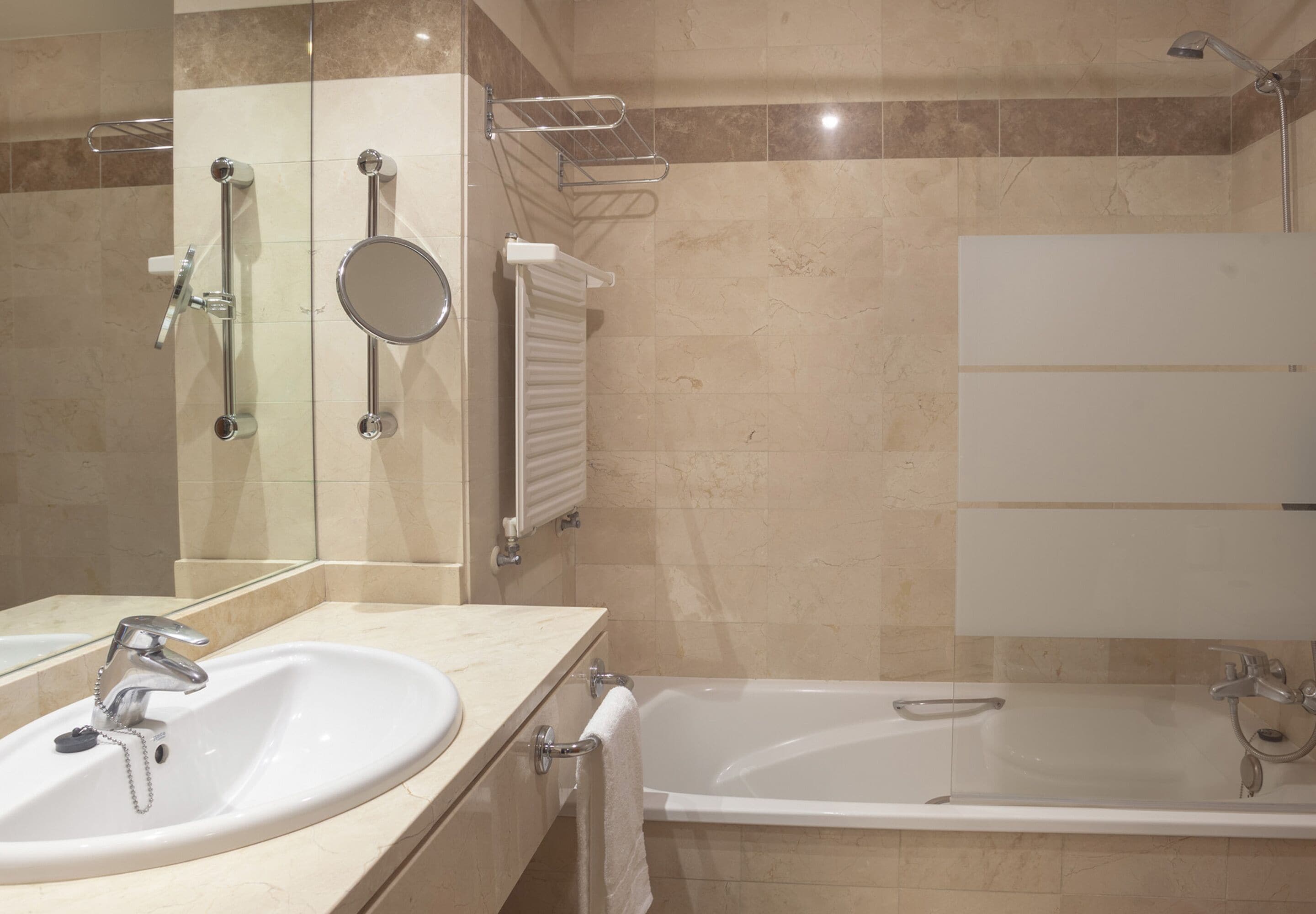 A modern bathroom with two sinks, a bathtub, and a shower.