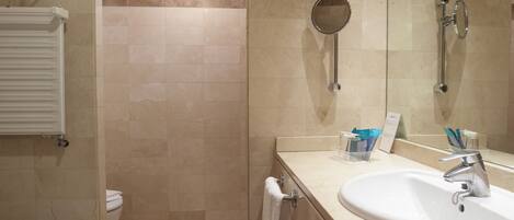 A bathroom with a white sink, a mirror, a towel rack, and a shower area.