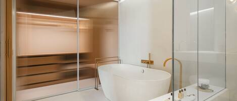 Un baño moderno con una bañera independiente, una cabina de ducha de vidrio y un tocador minimalista.
