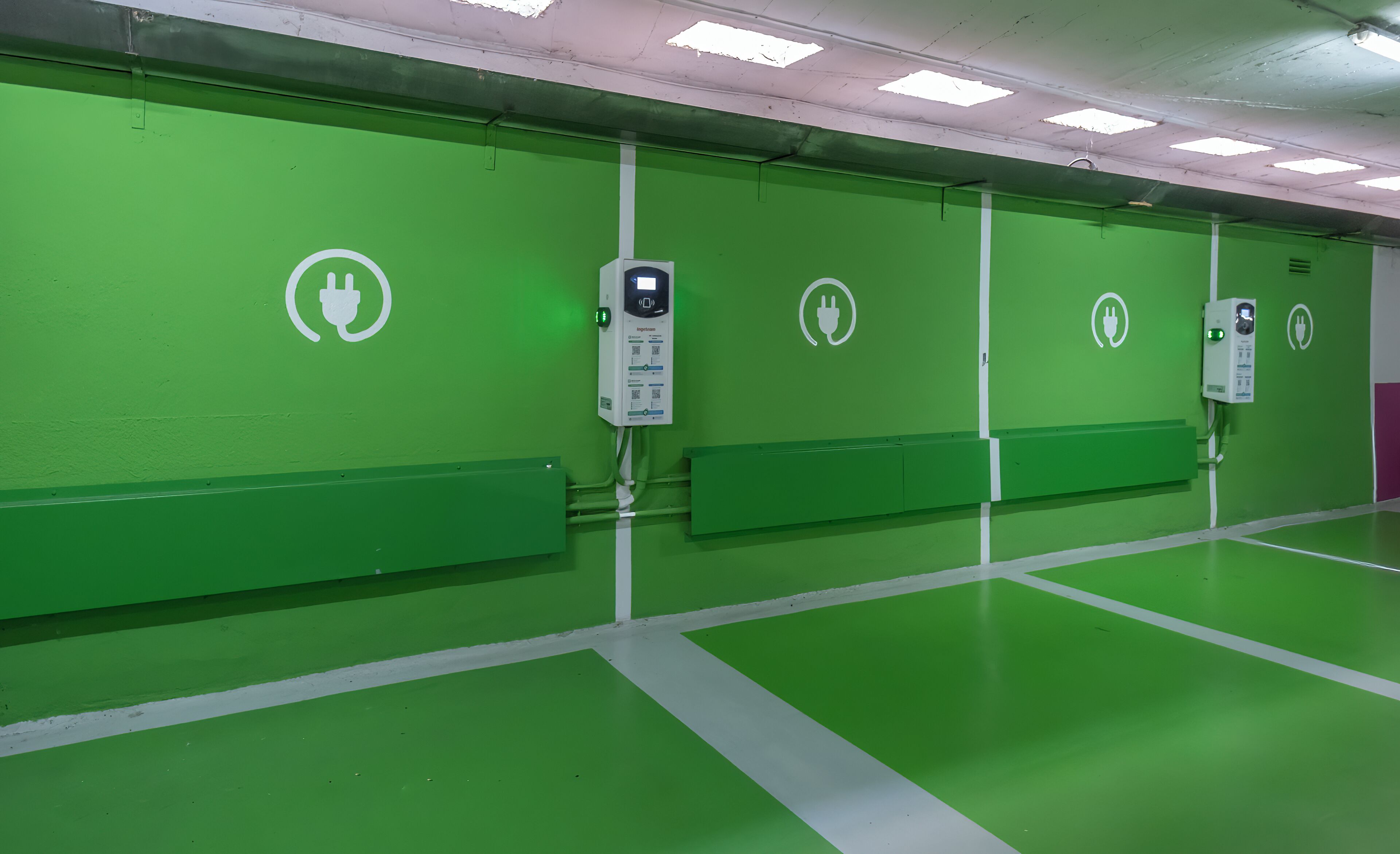 A green room with four electrical outlets on the wall, each with a plug symbol.